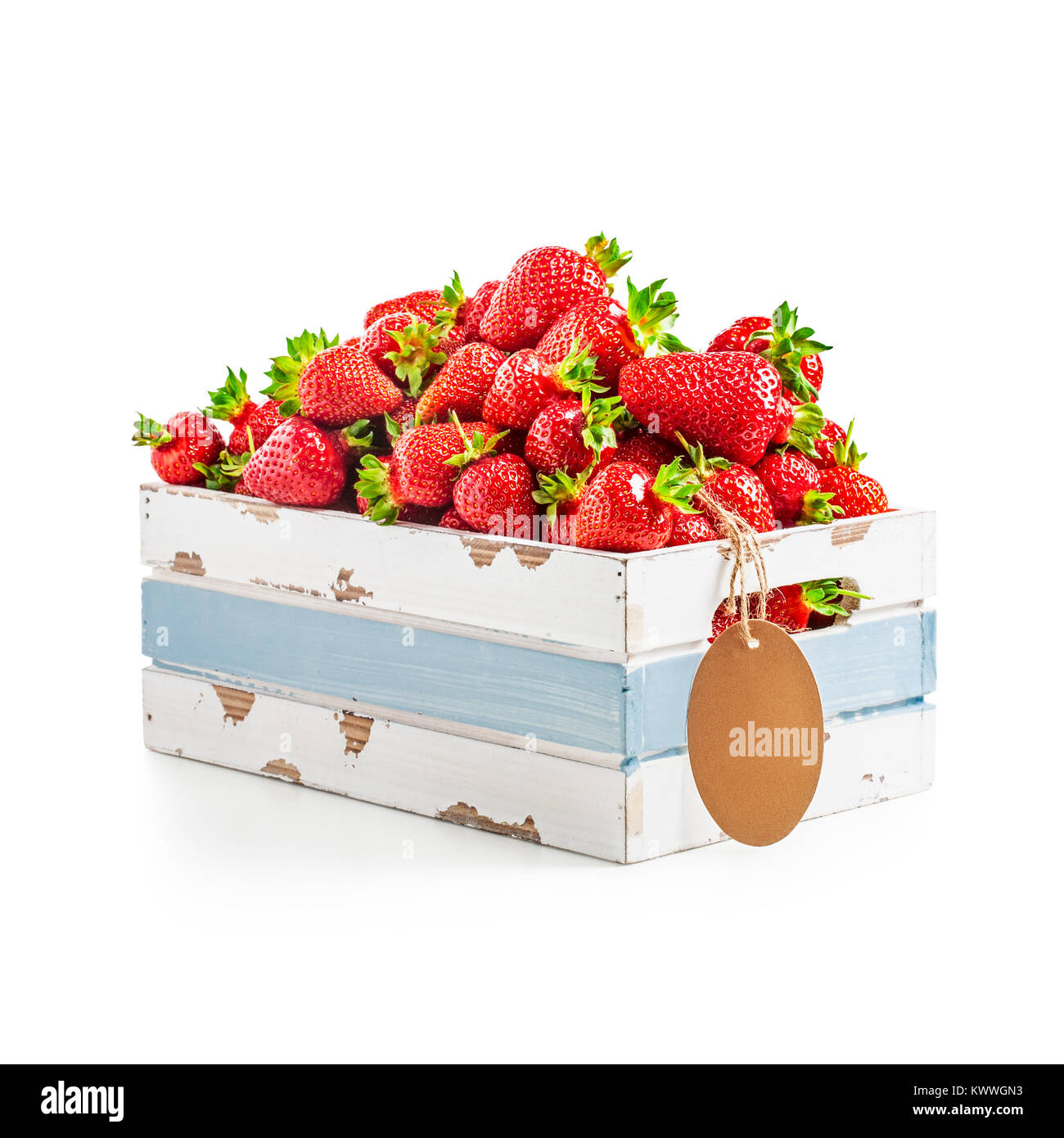 Fresh strawberries in old wooden crate with tag label isolated on white background. Healthy eating. Single object with clipping path Stock Photo