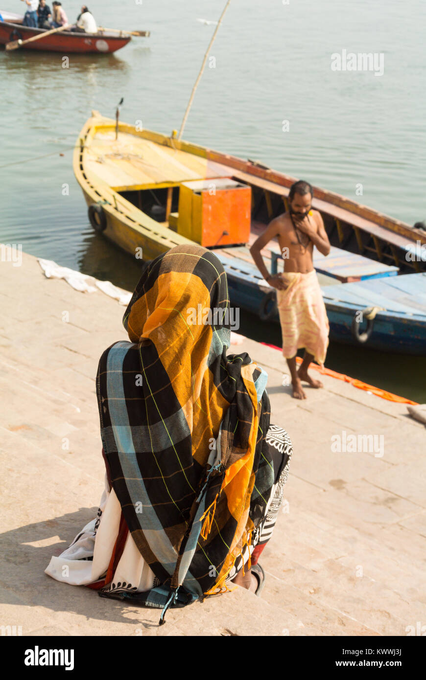 Indian woman sitting at a ghat on a ganges river, Varanasi, India Stock Photo