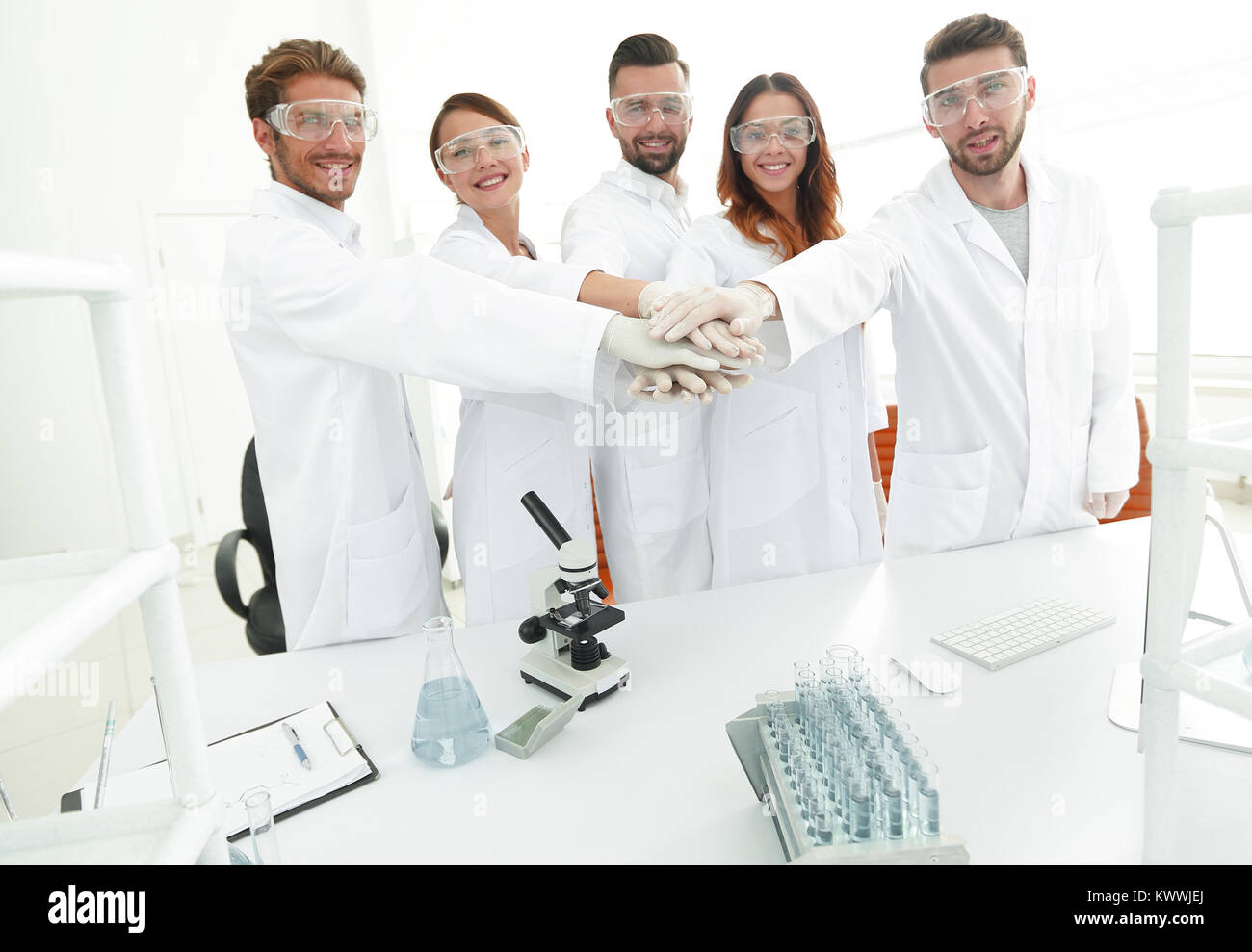 successful team of young scientists with hands clasped together.the ...
