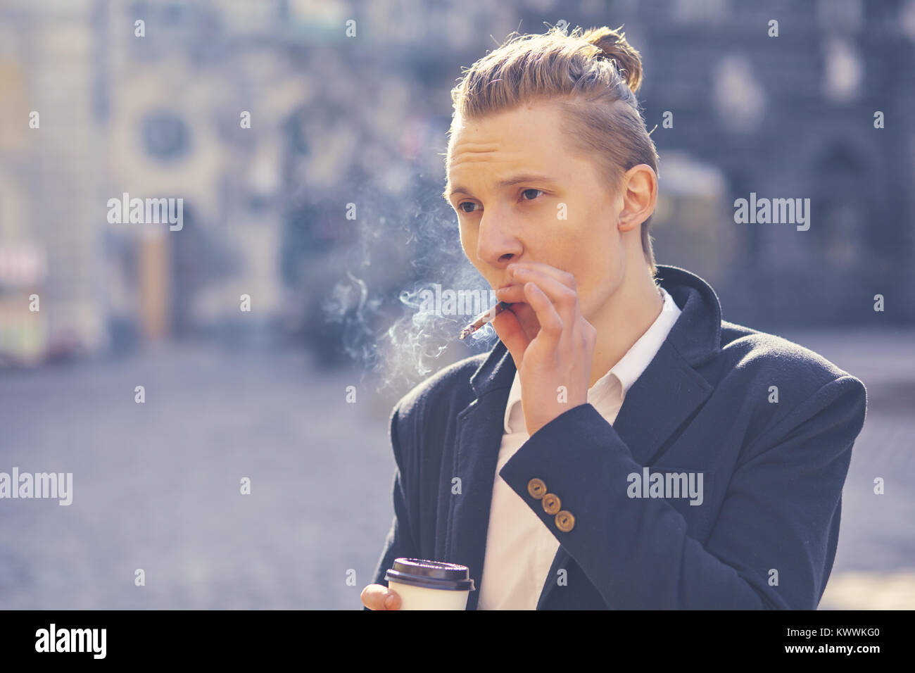 young handsome hipster man smoking cigarette Stock Photo