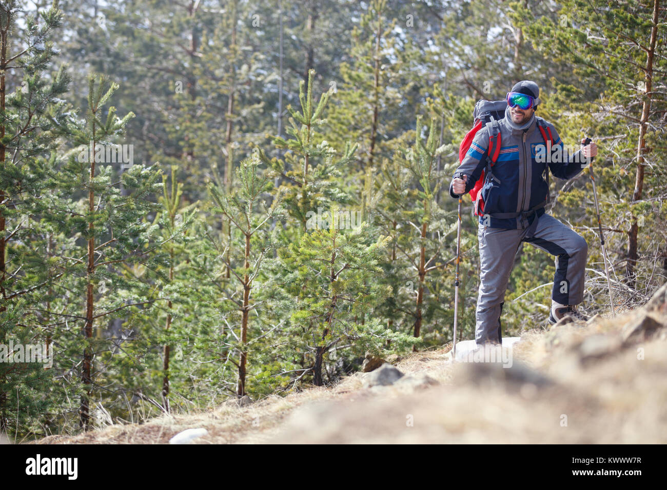 Male mountaineer with poles mountaineering on mountain Stock Photo