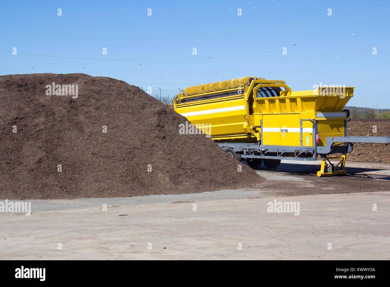 Industrial compost grinder mulching garden waste into compost Stock