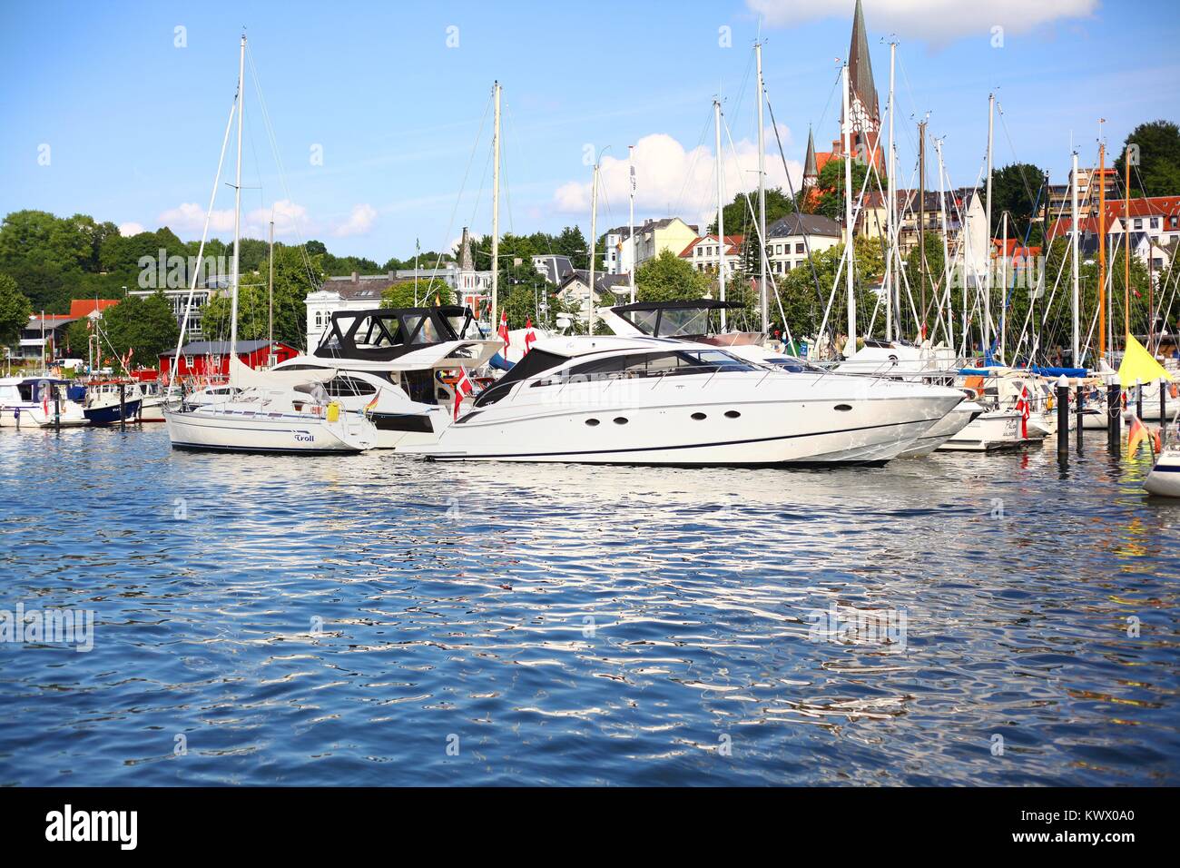 Schicke Yachten und Segelboote liegen in Flensburg (Schleswig-Holstein) am 26.07.2017 an der Förde im Hafen. Im Hintergrund ist die St. Jürgen-Kirche zu sehen. Foto: Wolfram Steinberg/dpa | usage worldwide Stock Photo