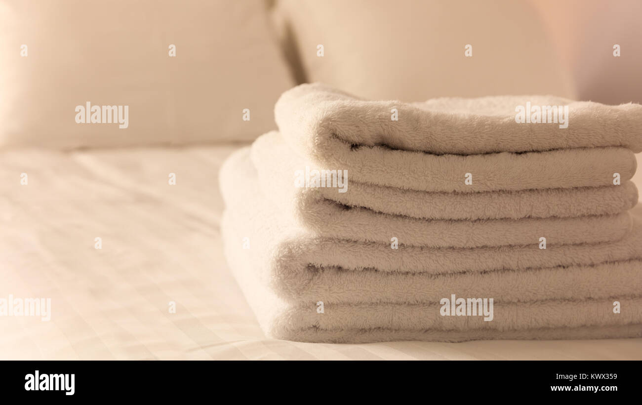 White Fluffy Towels On Bed In Hotel Bedroom Close Up View Stock