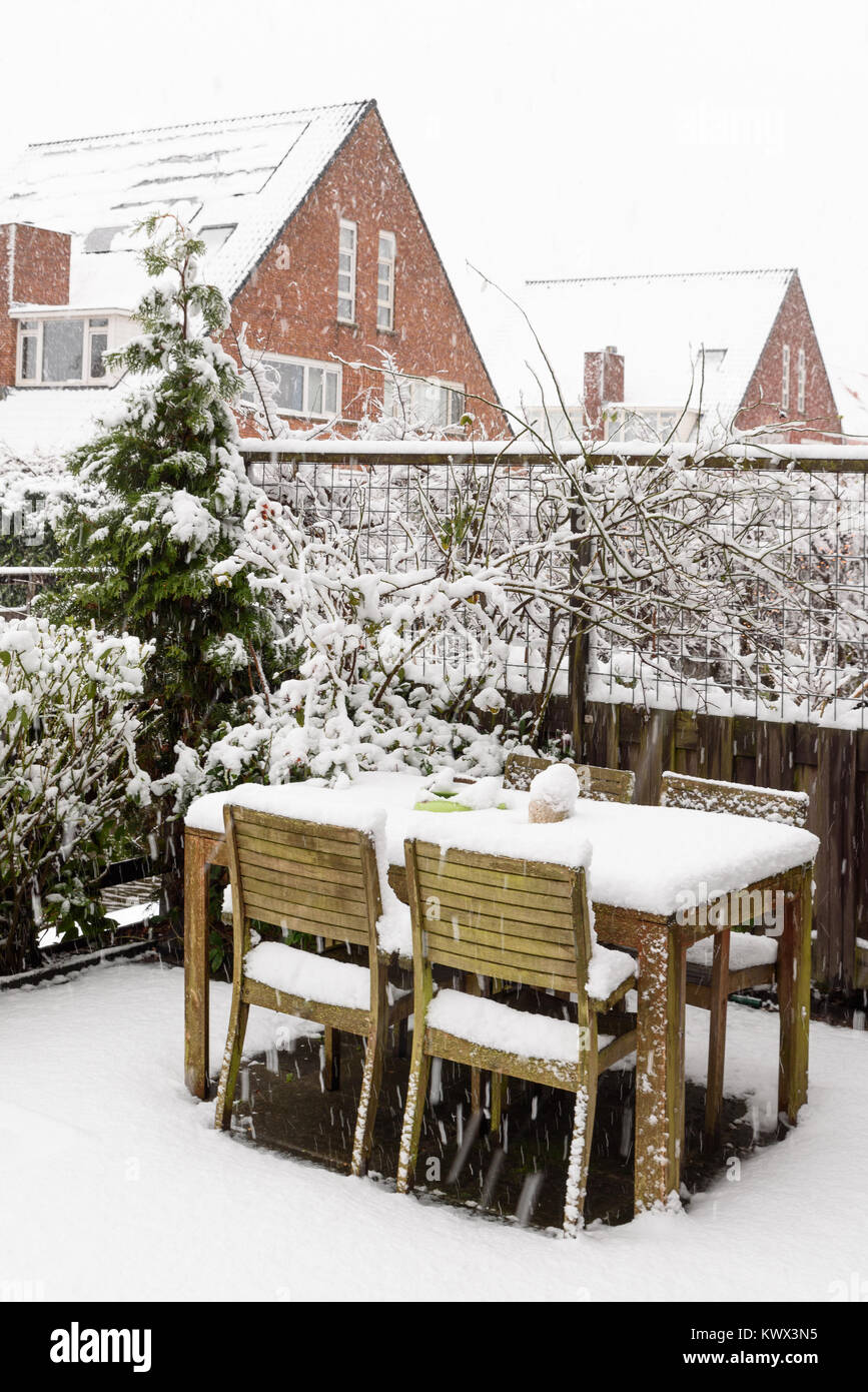 Garden backyard wooden table and chairs under snow Stock Photo