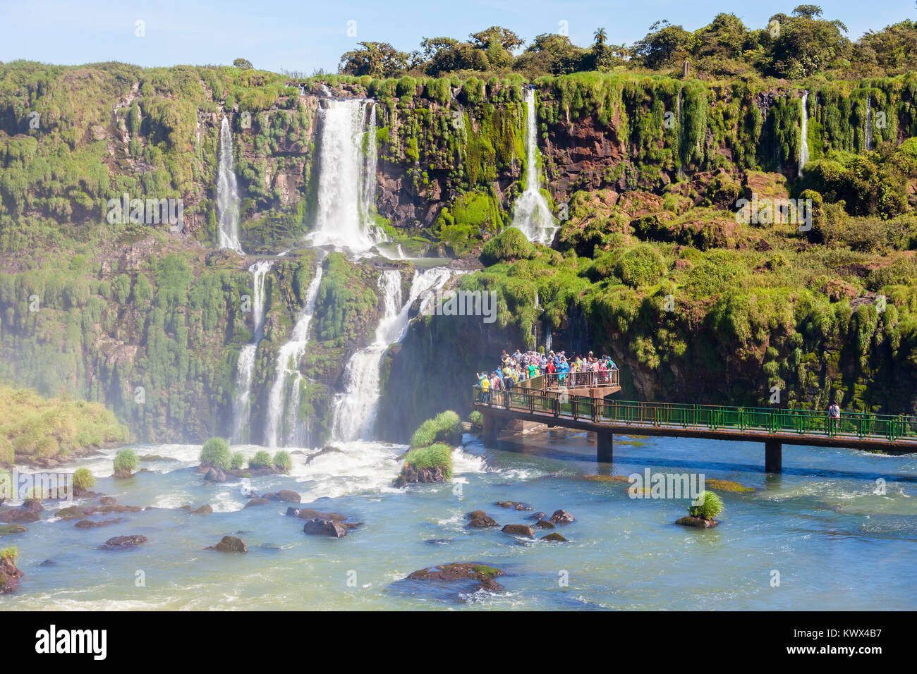 Tourists near the Iguazu Falls, waterfalls of the Iguazu River on the border of the Argentina and the Brazil. It's one of the New 7 Wonders of Nature. Stock Photo