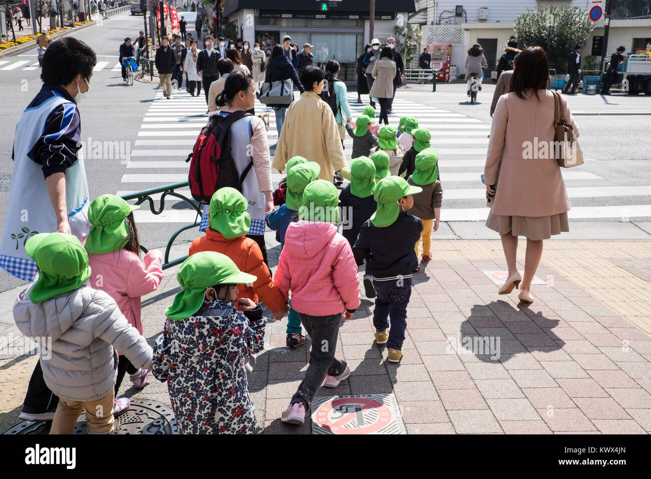 Japan, Tokyo, Honshu Island: group of children, pupils with a green cap, in a street Stock Photo