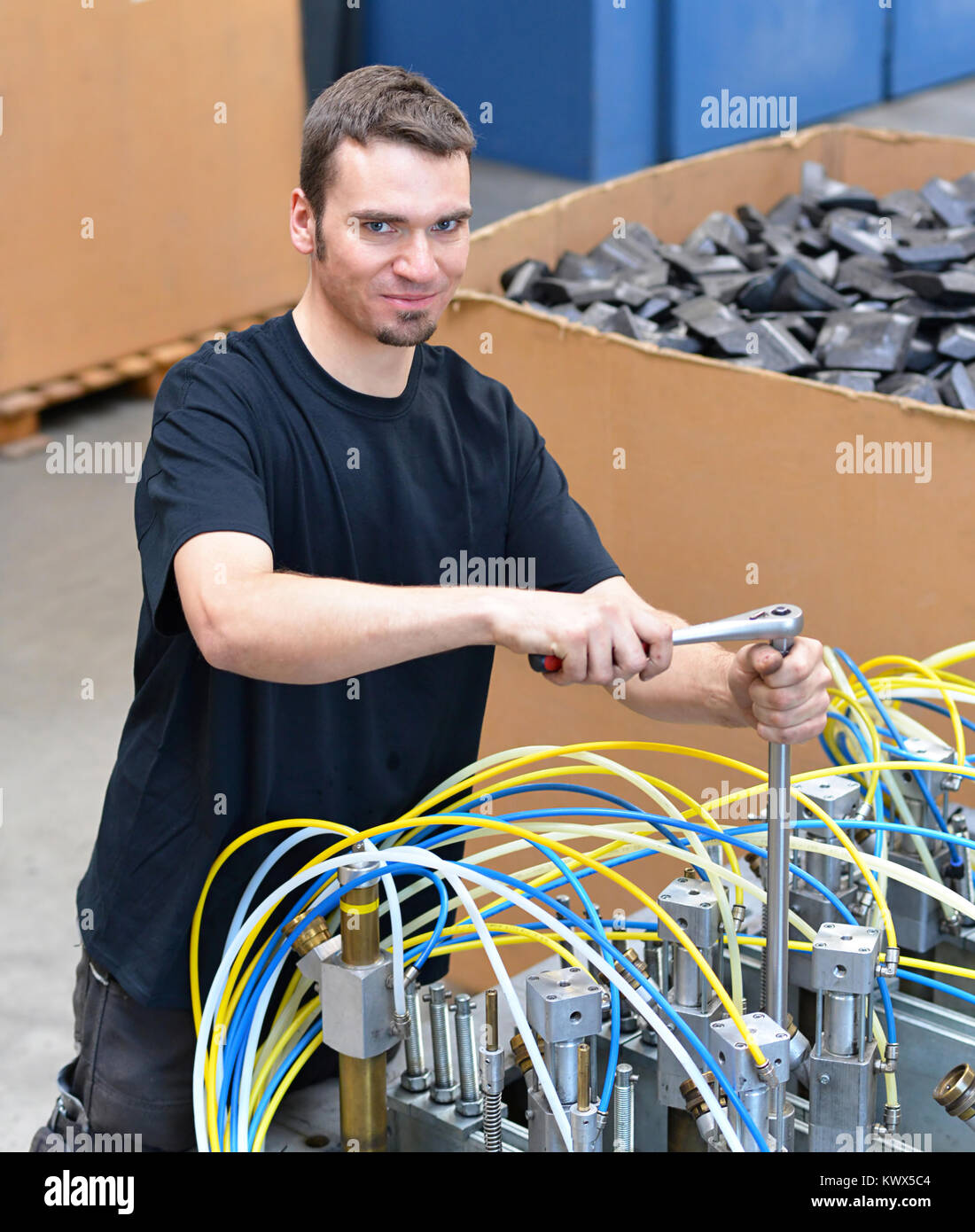 operator repairs a machine in an industrial plant with tools