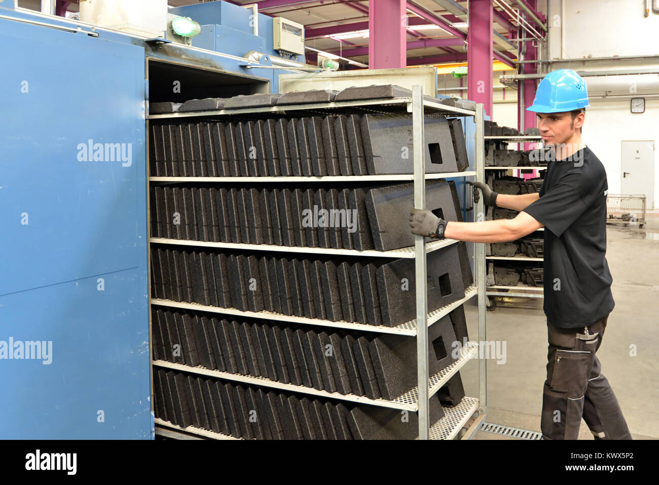 worker operates machine in the plastics industry - production of styrofoam components Stock Photo