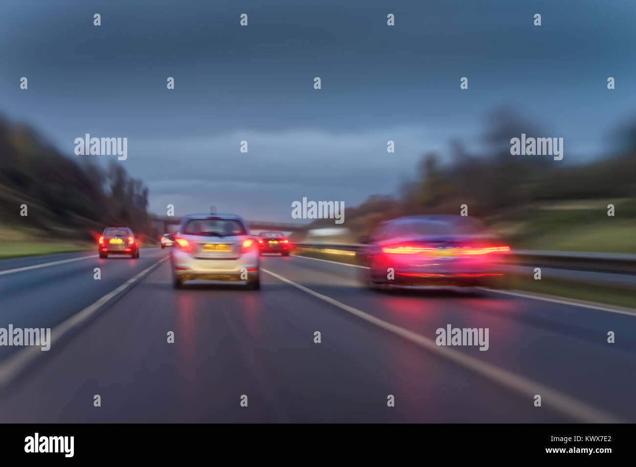 Fast moving cars on a  wet British motorway at dusk. Stock Photo