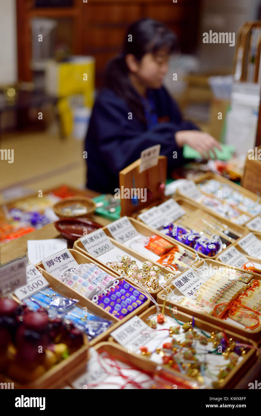 Woman selling fortune and good luck charms, Omamori amulets, at Kiyomizu-dera Buddhist temple shop in Higashiyama, Kyoto, Japan 2017. Stock Photo