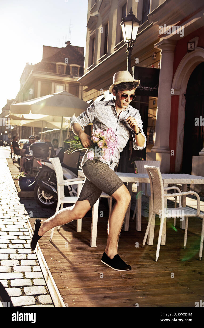 Young guy running and holdingpinky roses Stock Photo - Alamy