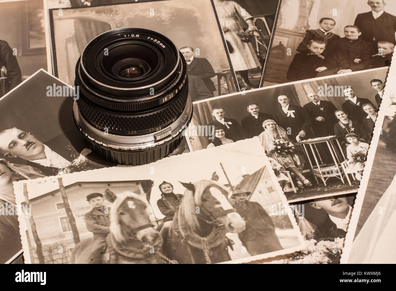 Vintage photographs next to an old camera lens Stock Photo