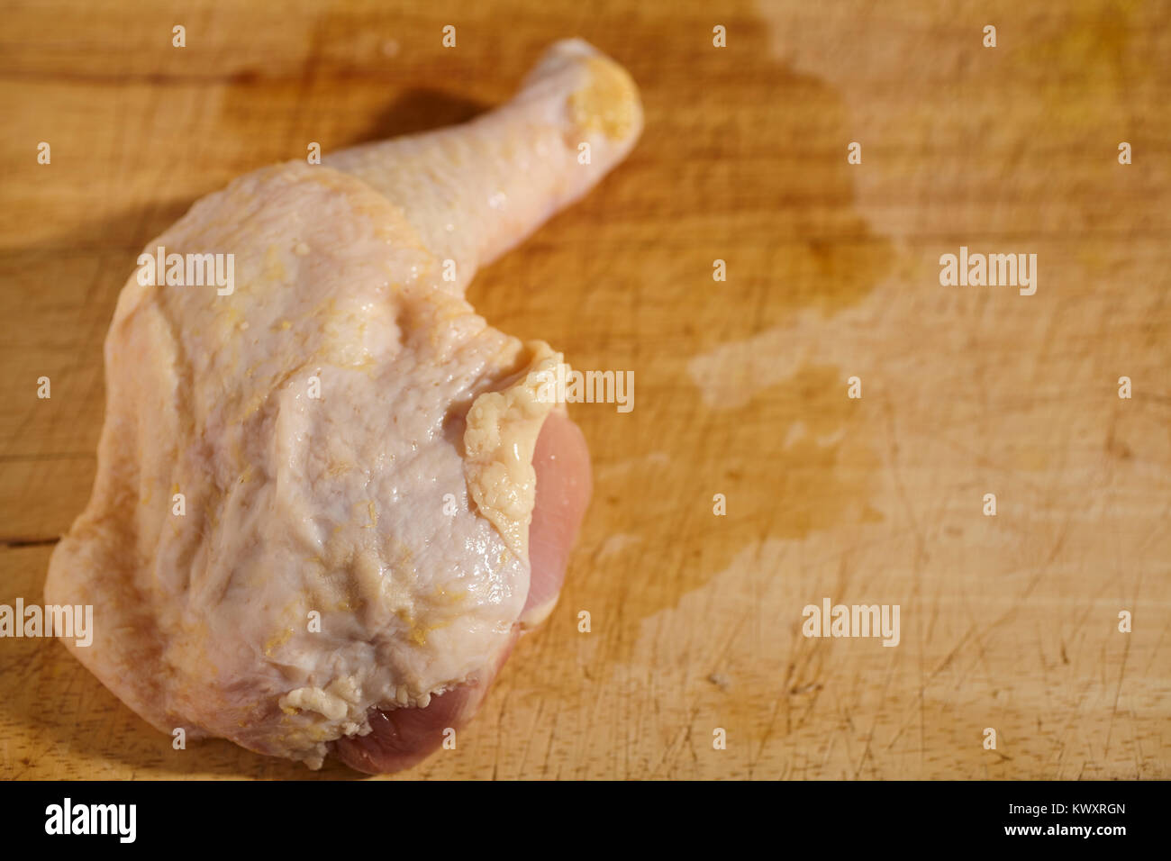 raw chicken leg and thigh on a wood butcher block Stock Photo