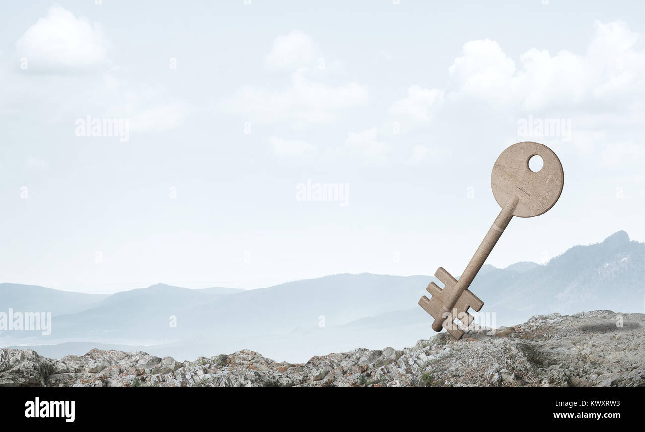 Key stone figure as symbol of access on green hill Stock Photo - Alamy