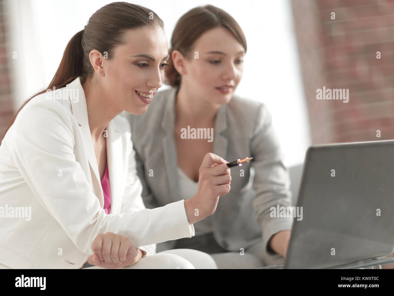 Discuss Info business people. female colleagues discuss information shown on the ...