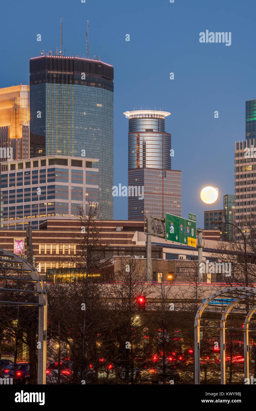 Full moon rises between buildings on the Minneapolis skyline Stock