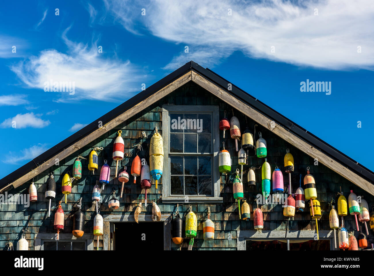 Lobster bouys adorn the side of a traditional cedar shaked building along the coast of Maine. Stock Photo