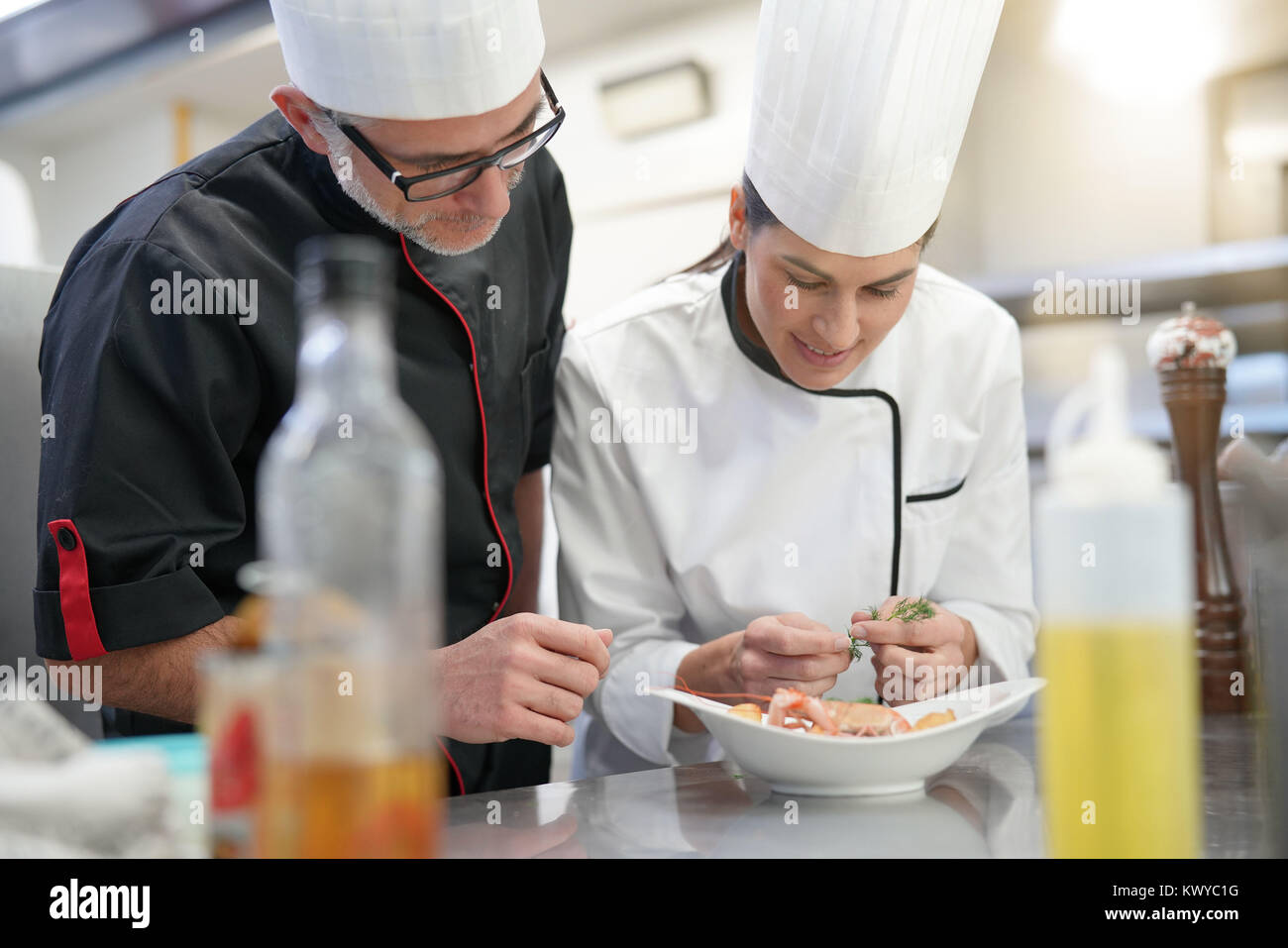 Professional cook chefs in kitchen improving dish composition Stock ...