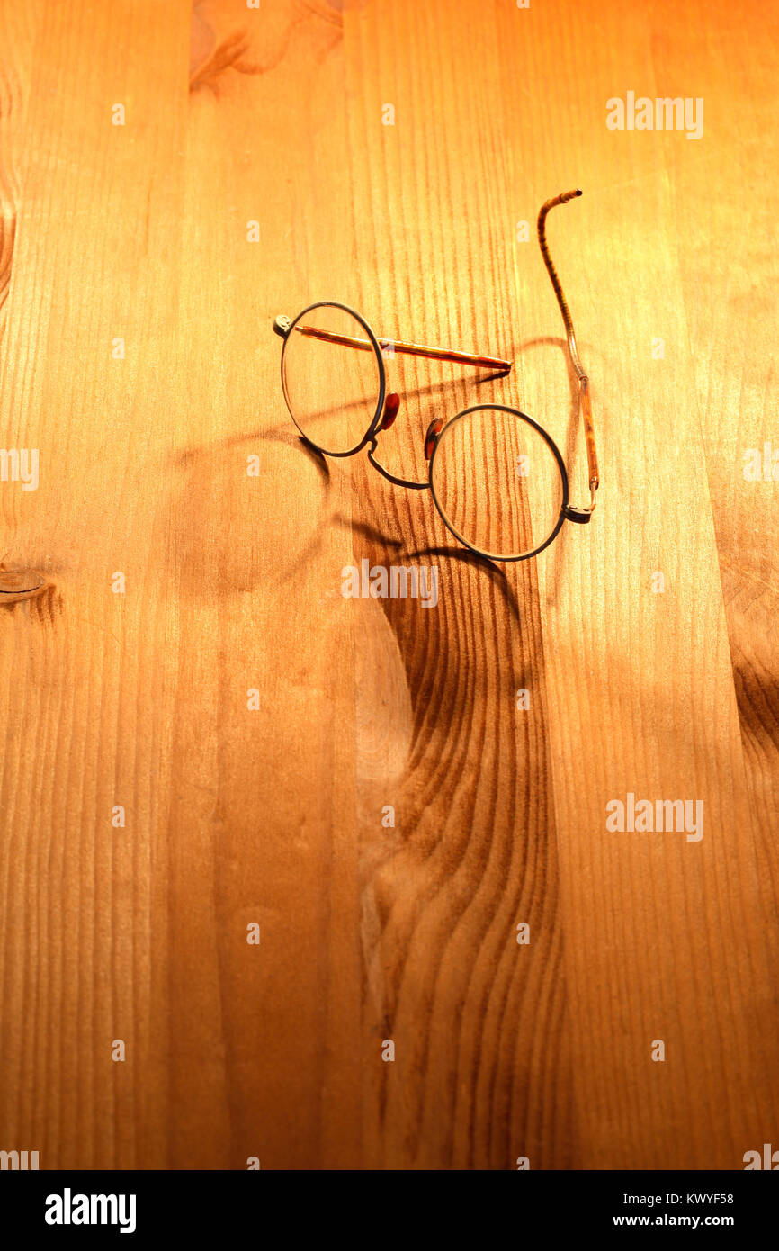 Vintage spectacles lying on nice yellow wooden background Stock Photo
