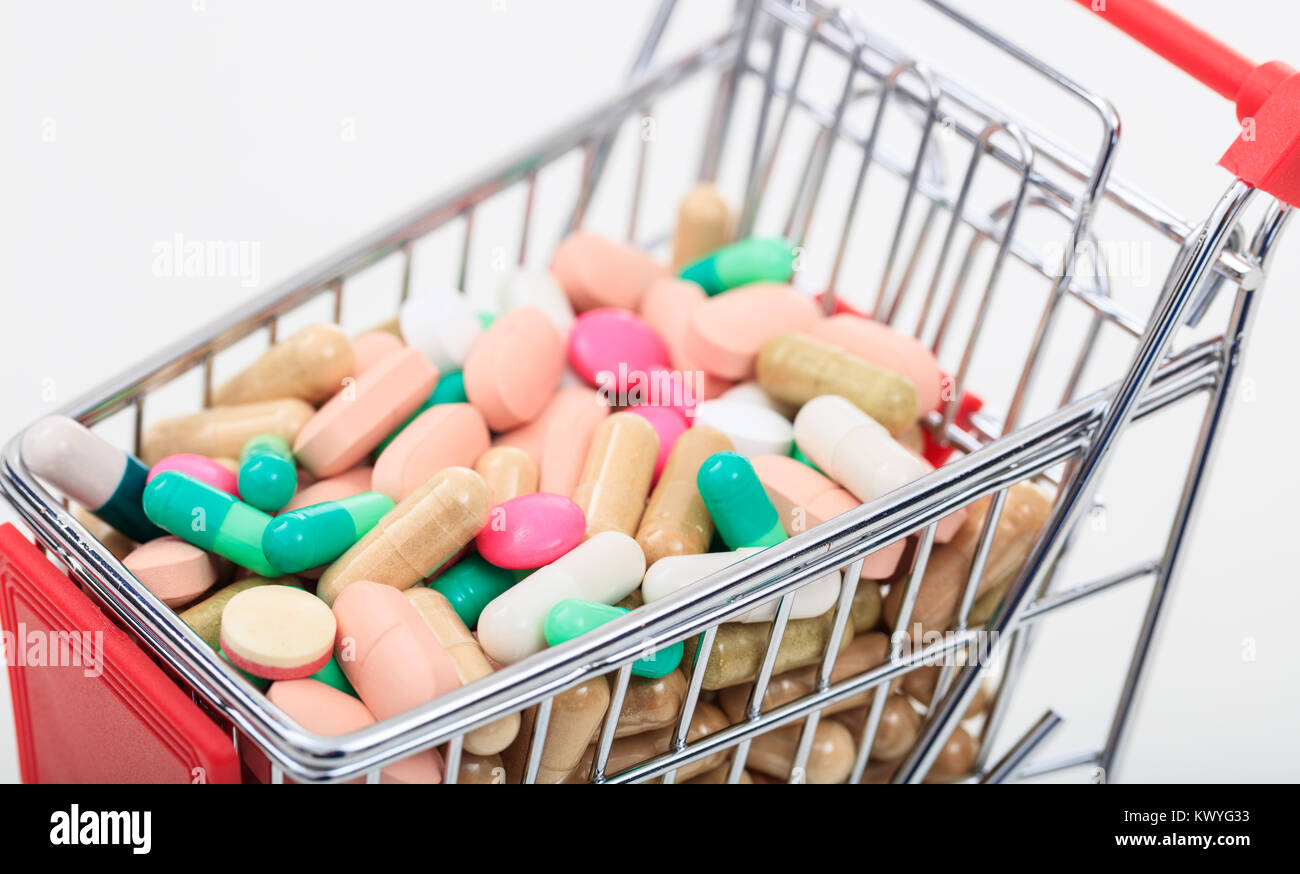 Trolley with colorful pills on white background Stock Photo