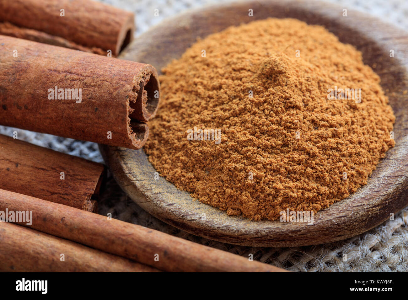 Cinnamon sticks and powder on a sackcloth Stock Photo