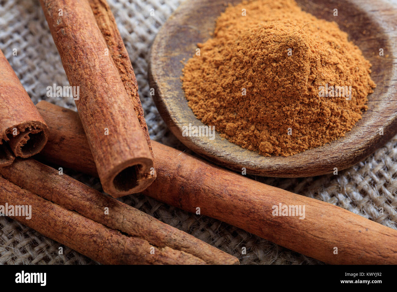 Cinnamon sticks and powder on a sackcloth Stock Photo