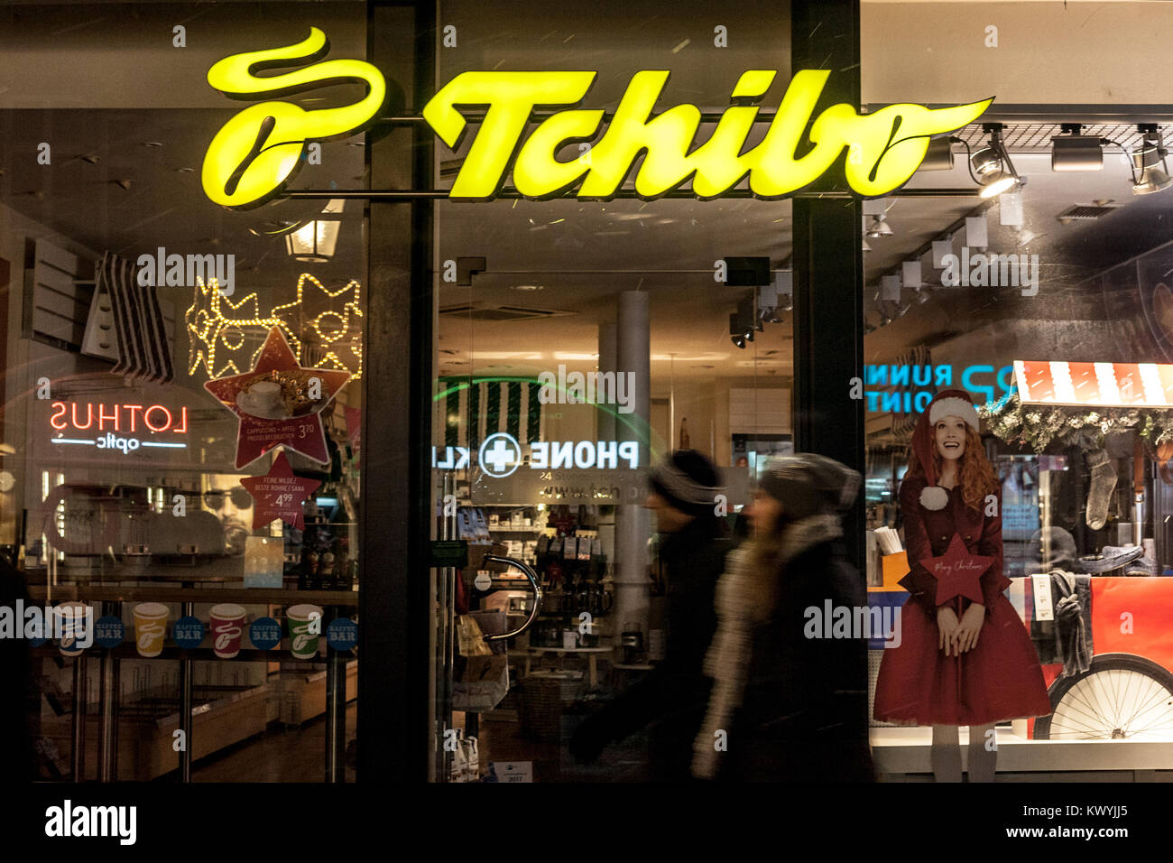 MUNICH, GERMANY - DECEMBER 17, 2017: Tchibo logo on their Munich main shop taken at night. Tchibo is a German chain of coffee retailers and cafés know Stock Photo