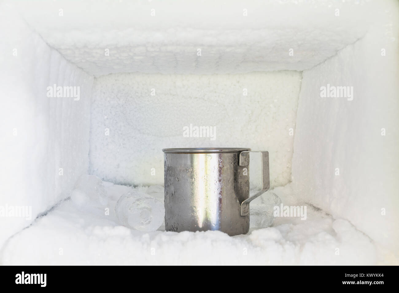 Stainless steel drinking water glass in freezer of a refrigerator. Ice  buildup inside of a freezer walls Stock Photo - Alamy