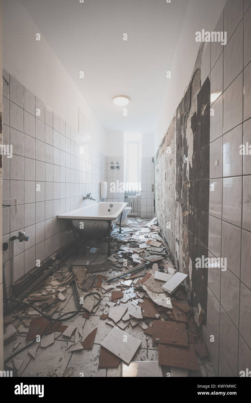bathroom renovation - removing tiles in old apartment bathroom - Stock Photo