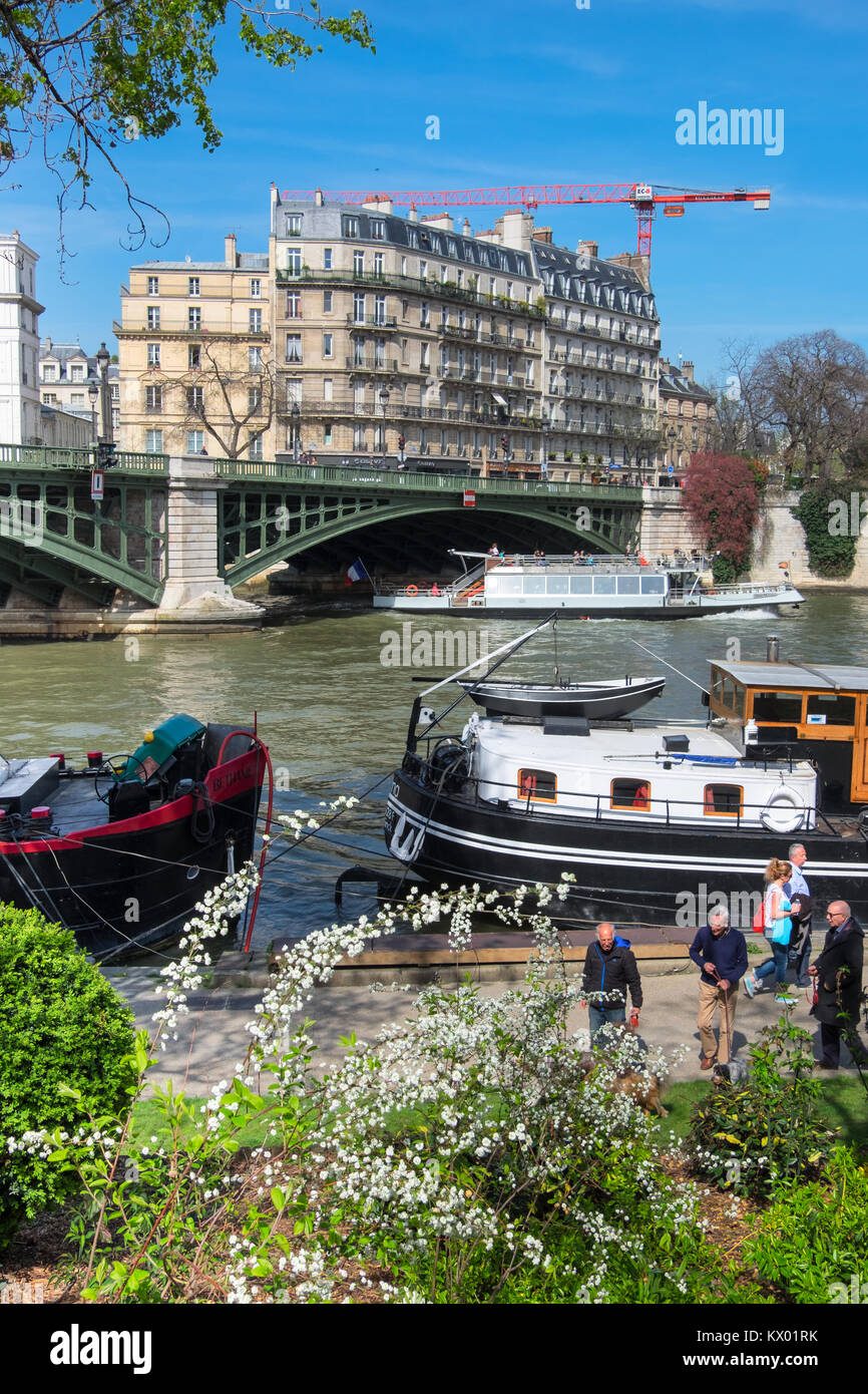 PARIS, FRANCE APRIL 20 2016 Passenger boats pass Ile SaintLouis, as
