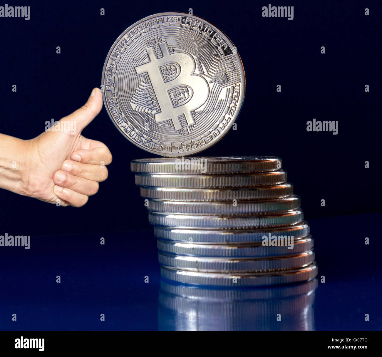 On a blue background are silver coins of a digital crypto currency Bitcoin.  In addition to the lying coins, there is standing bitcoin. The thumbs sup  Stock Photo - Alamy