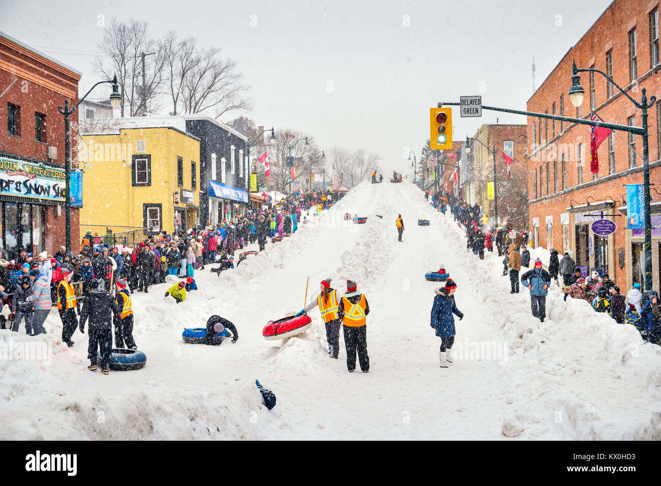 Crowd stands in line in order to toboggan during the Fire and Ice Festival in downtown Bracebridge, Ontario, Canada. Stock Photo