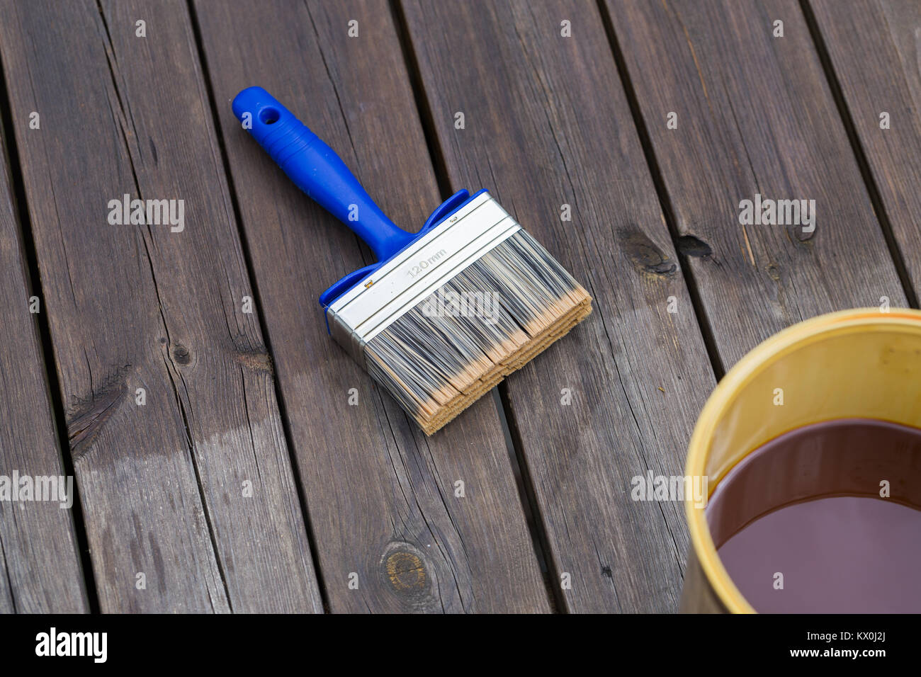 Oiling Terrace Rail with Wide Brush painting wooden patio deck with