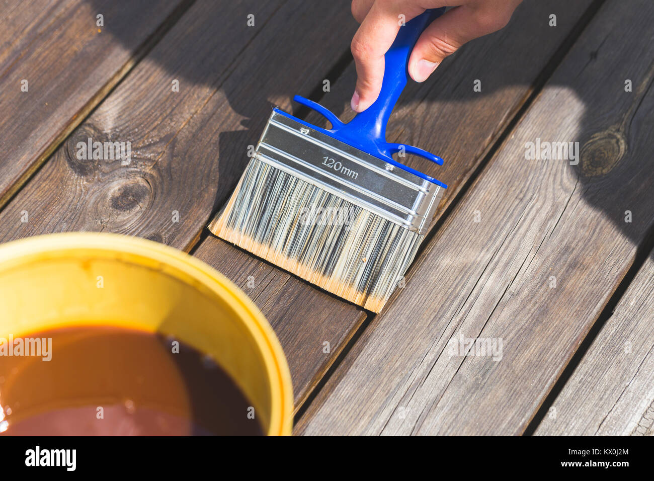 Oiling Terrace Rail with Wide Brush painting wooden patio deck with