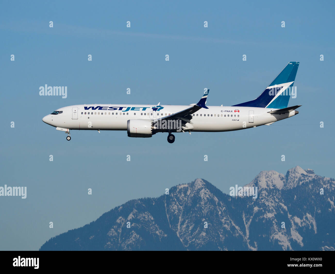 WestJet Airlines plane jet airplane aeroplane airliner jetliner Boeing 737-8 Max airborne final approach landing Stock Photo