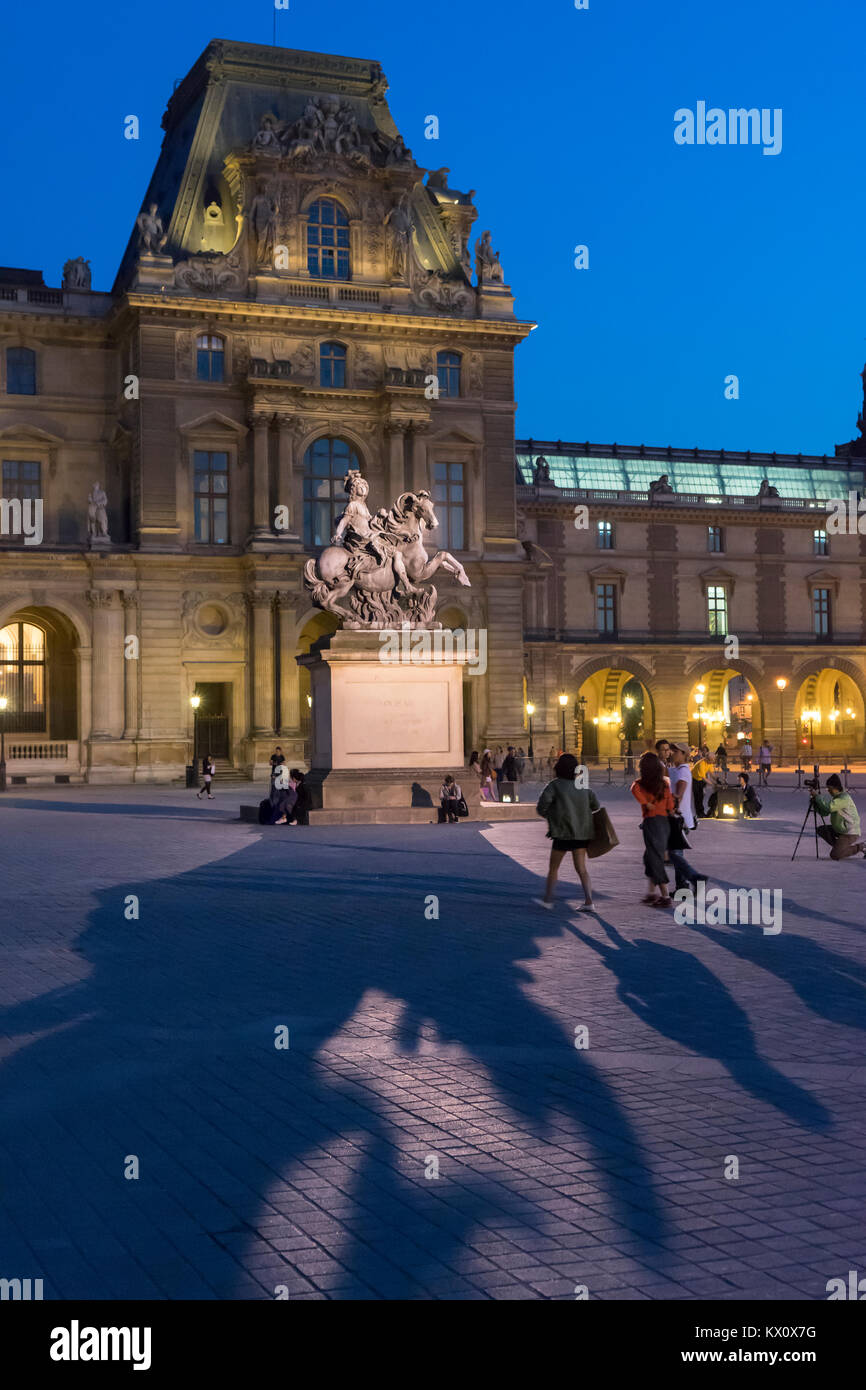 France, Paris (75), Louvre at dusk with the statue of Louis XIV Stock Photo