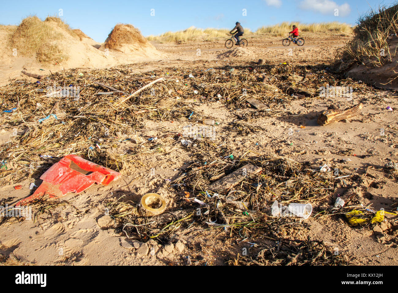 Crosby beach, Liverpool, Merseyside UK. Dumped drinks cups, plastic cutlery, straws, plastic bottles, lids stirrers, buckets, polythene, single-use, throwaway items, string, rope, lighters, man-made chemicals, plastics, tide of plastic, plastic bottled drinks, waste, bags, bottles, wrapping, marine litter, trash, containers, packaging, microplastics, rubbish, sea-borne refuse, on the coastal shoreline. Stock Photo