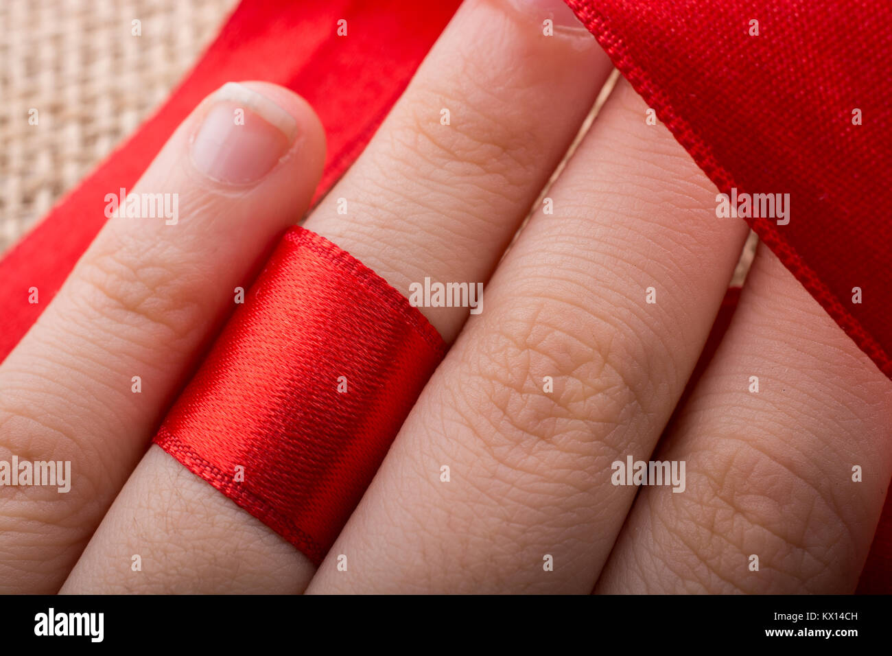 Red string tied around ring finger of the hand Stock Photo - Alamy