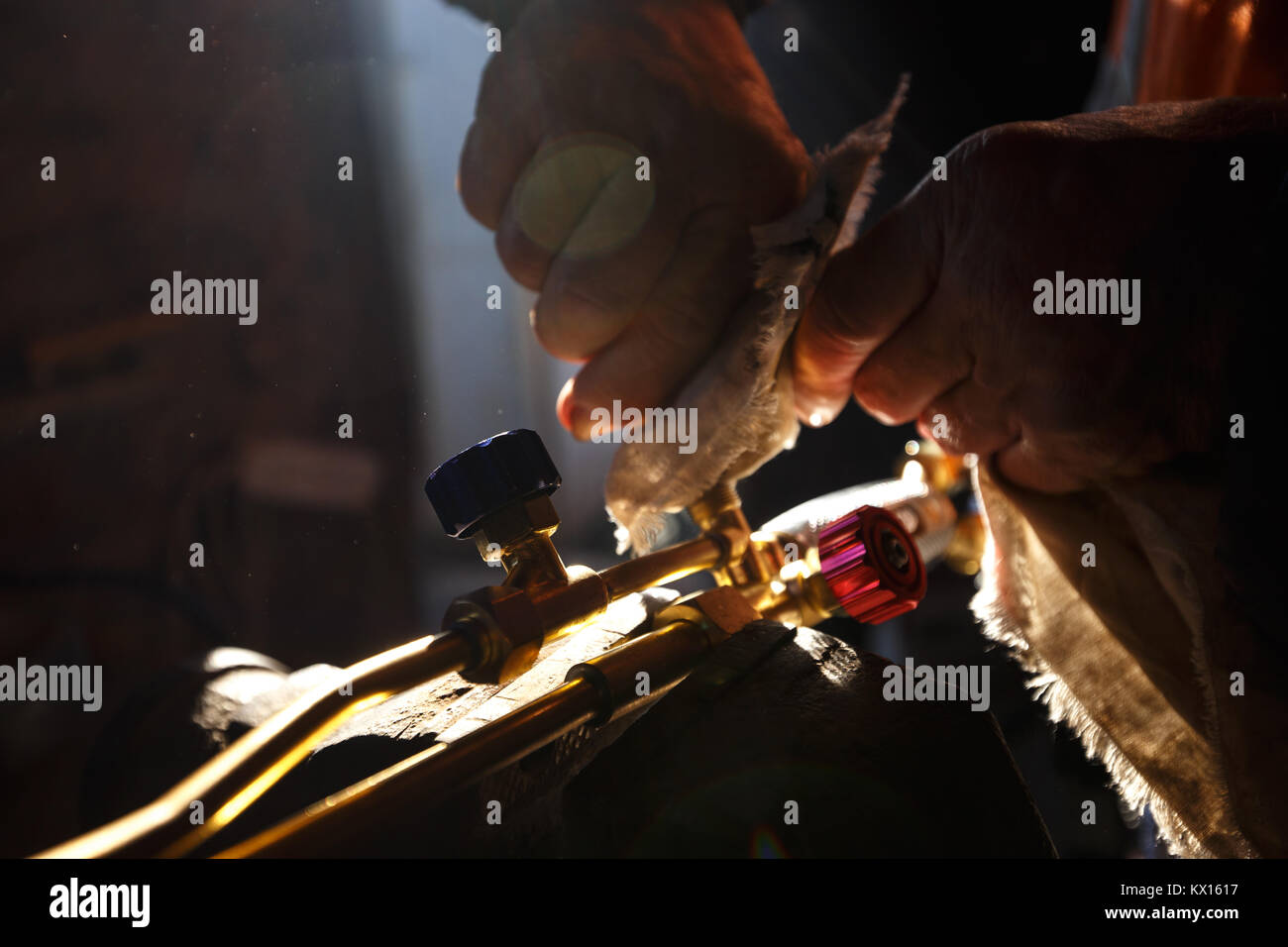 Man cleaning oxy acetylene torch propane tools for cutting metal in his workshop. Stock Photo