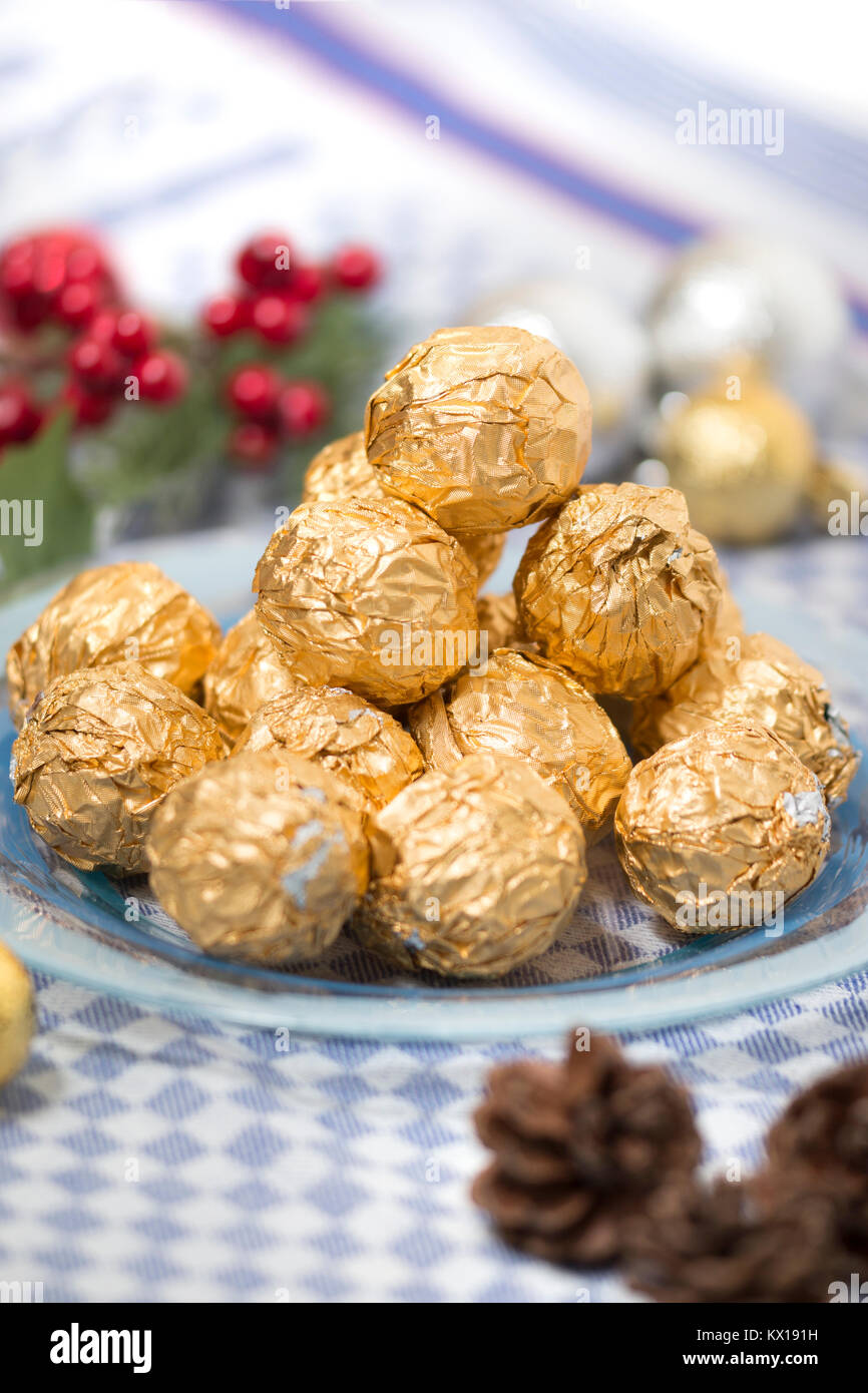 Chocolate candy balls wrapped on beautiful golden paper with xmas ...