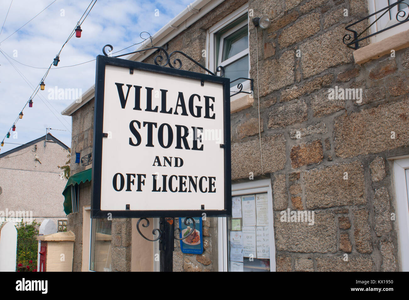 A village stores and off licence sign - John Gollop Stock Photo