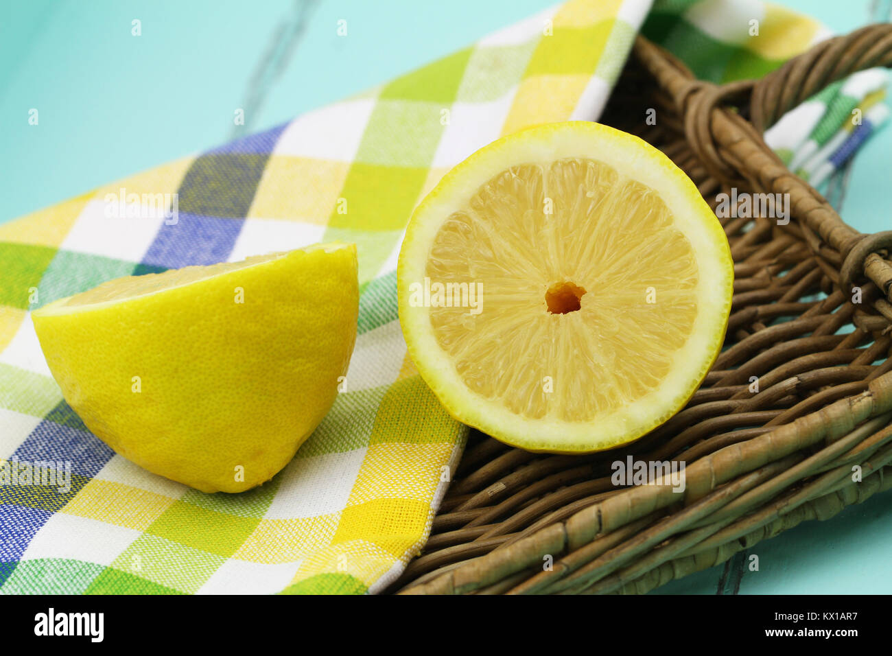 Two juicy lemon halves on wicker tray, closeup Stock Photo