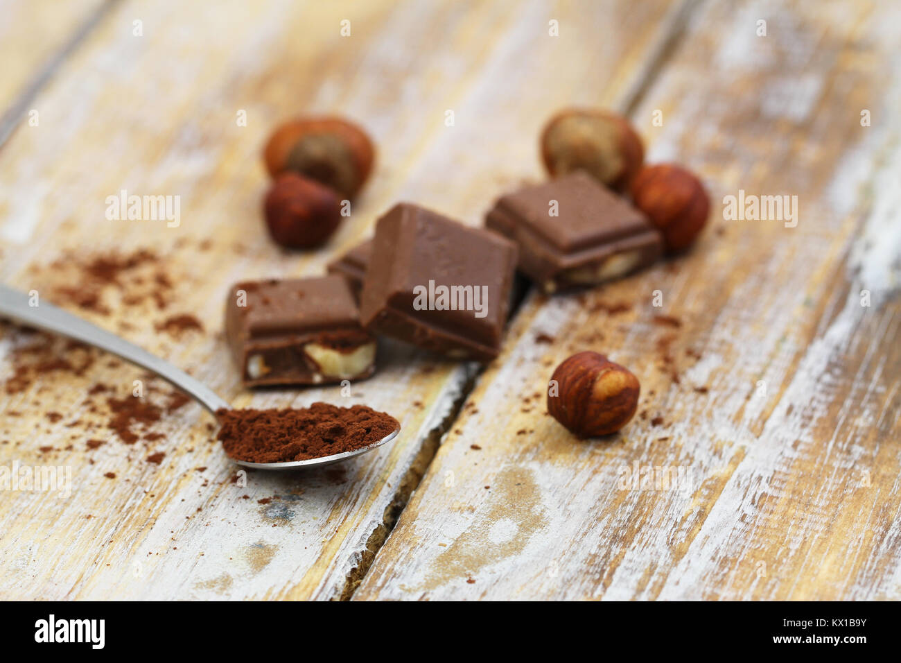 Spoonful of cocoa powder with milk chocolate on rustic wooden surface Stock Photo
