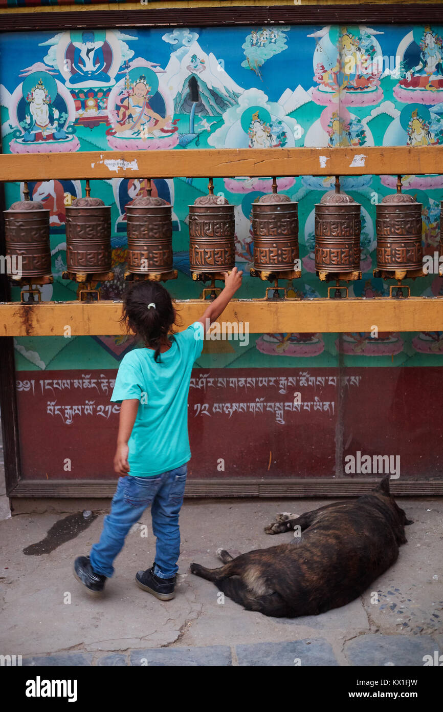 Little girl spinning prayer wheel, Boudhanath, Kathmandu, Nepal Stock Photo