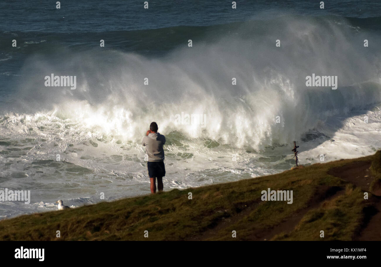 Fistral Beach, Newquay, UK. 6th Jan, 2018. UK Weather. Sunlit the Legendary Cribbar point wave breaks for a spectator. Fistral Beach, Newquay, UK 6th, January, 2018 Credit: Robert Taylor/Alamy Live News Stock Photo