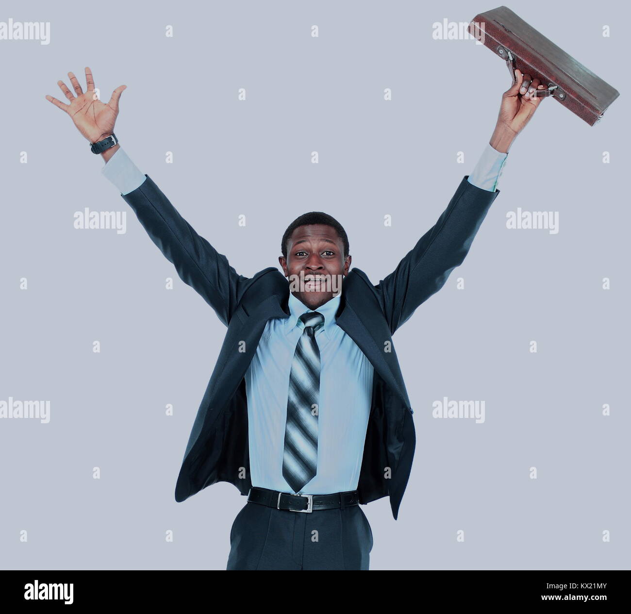 Full length of an excited handsome business man with arms raised in ...