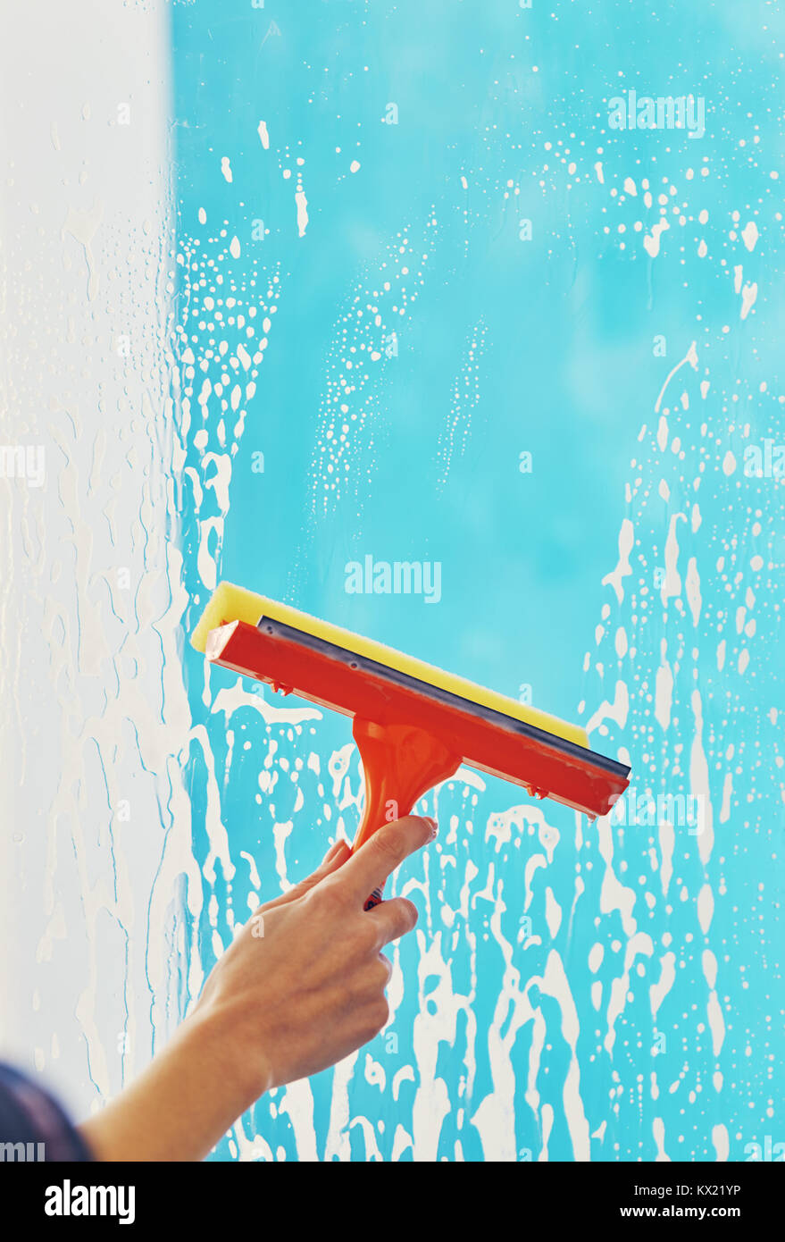 female hand cleans the window with a foam rubber brush Stock Photo Alamy