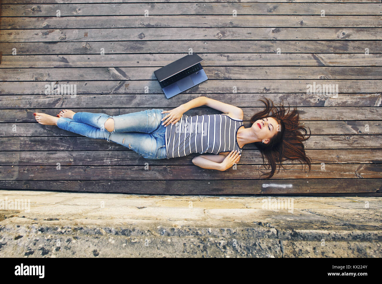 girl relaxing on a wooden floor . Relax, rest, education concept, recreation . Stock Photo