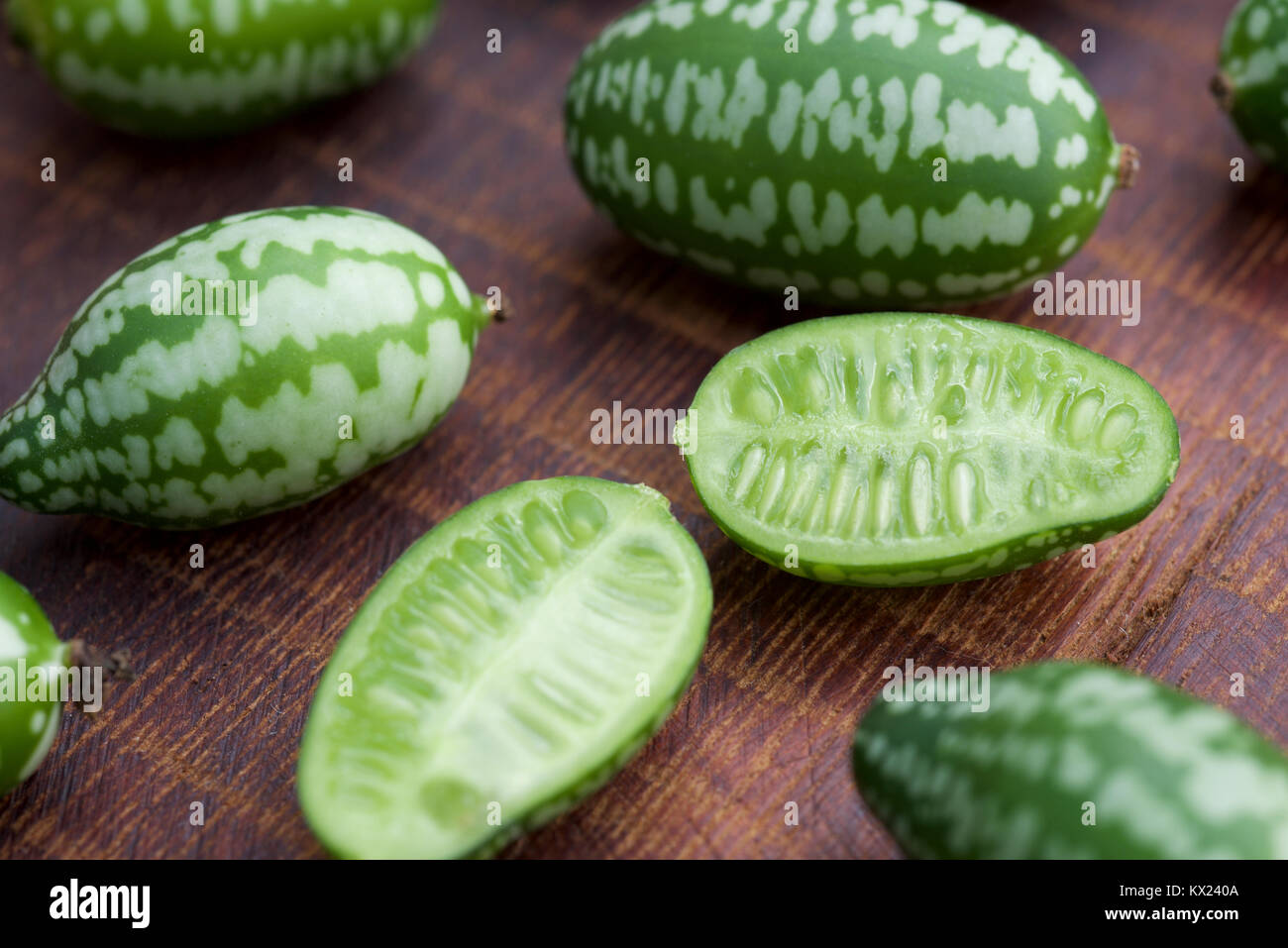 Cucamelon fruit, also known as Mexican gherkins, Mexican sour cucumbers, or Melothria Scabra on a dark brown wood grain background Stock Photo